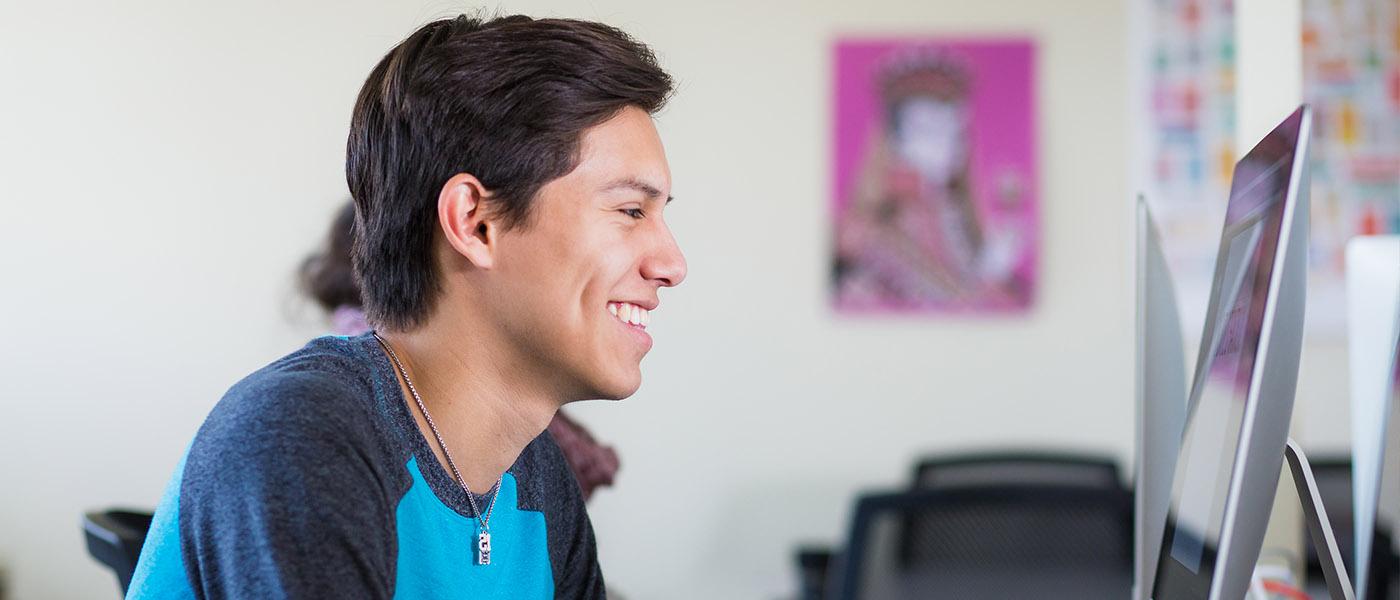 Close up from the side of student at his Mac workstation during class